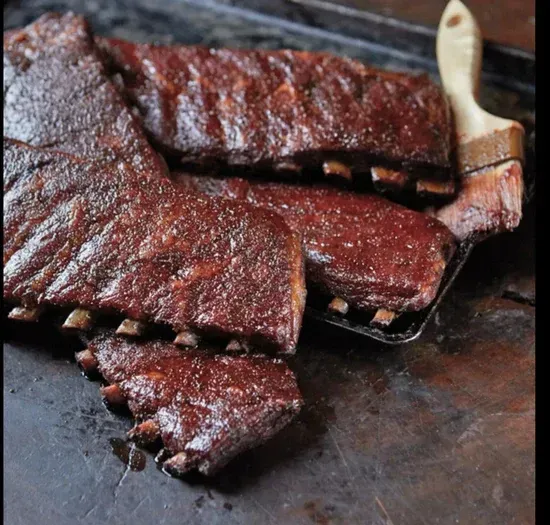 a tray of ribs with a brush next to it