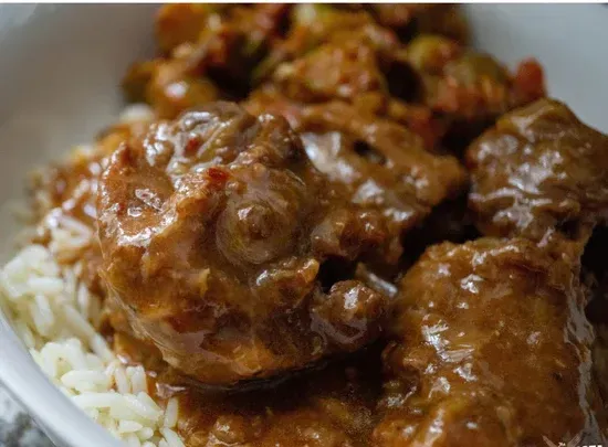 a close up of a bowl of stew over rice .