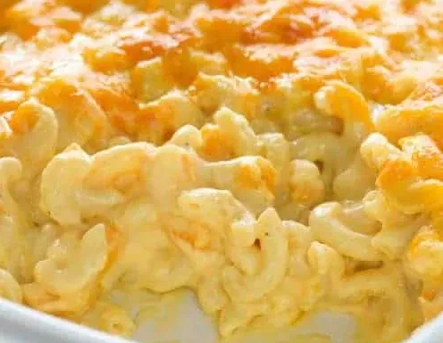 a casserole dish filled with macaroni and cheese with a scoop taken out of it .