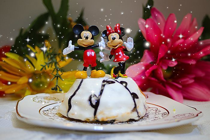 mickey mouse and minnie mouse figurines on top of a cake