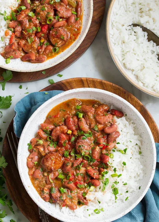 a bowl of red beans and rice on a wooden plate