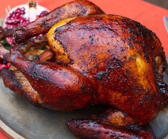 a roasted turkey is sitting on a wooden cutting board