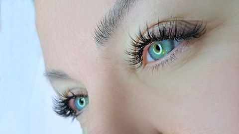A close up of a woman 's eyes with long eyelashes.