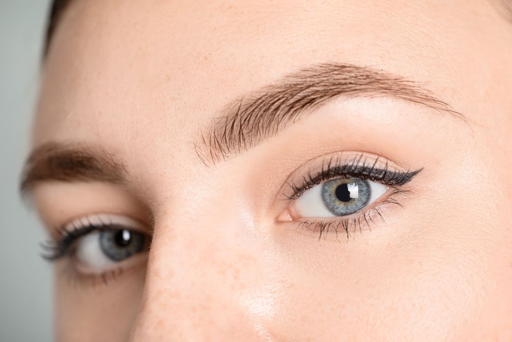 A close up of a woman 's eye with a blue eye.