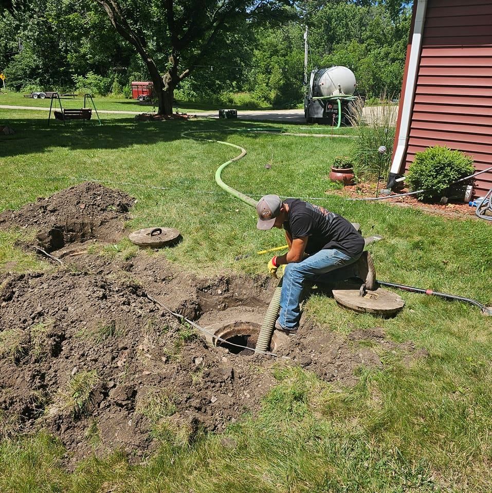A man is working on a septic tank in a yard.