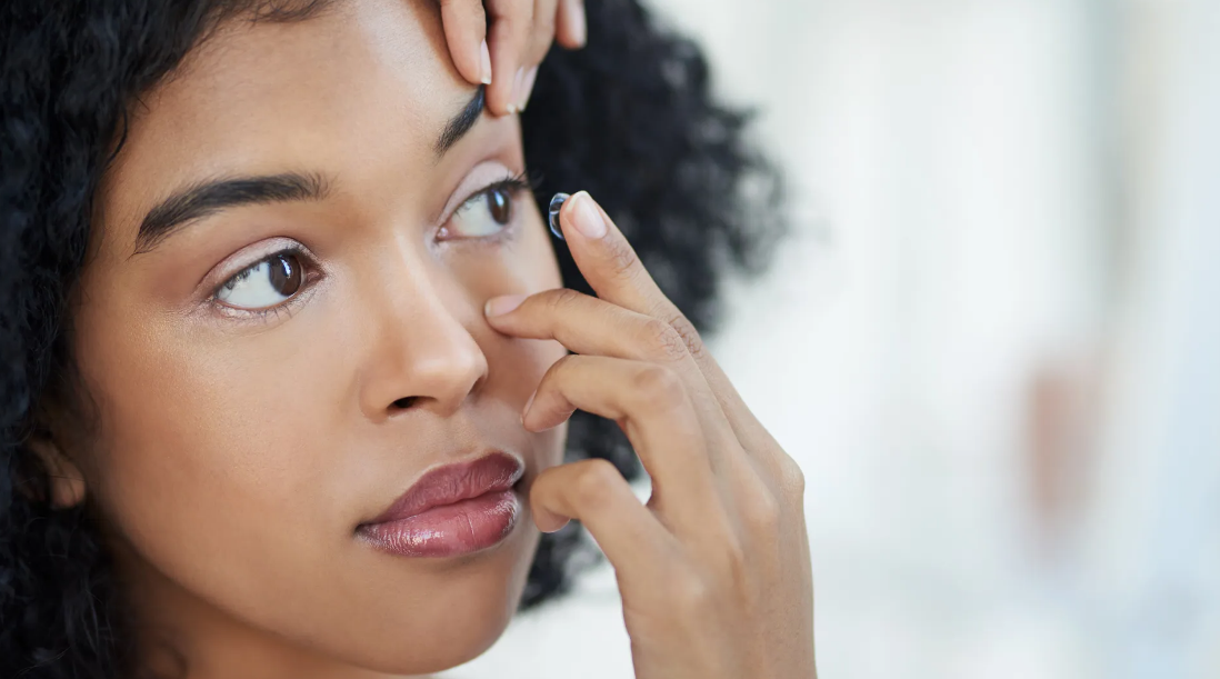 Woman Putting On Contact Lens — Eastpointe, MI — Black & White Look Optical
