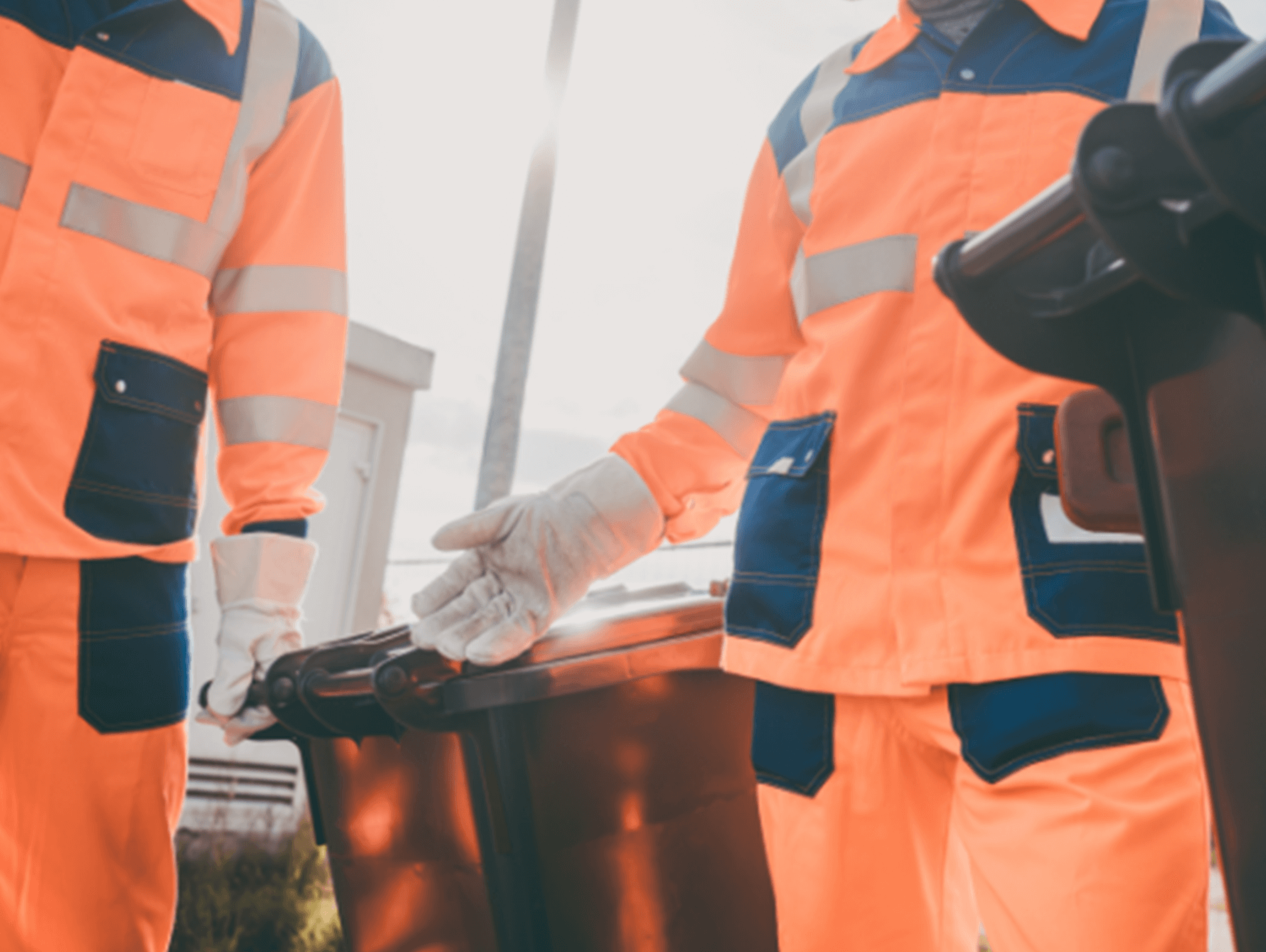 Garbage men working together to empty dustbins for trash removal, efficiently collecting and disposing of waste.