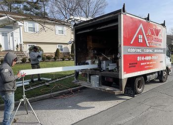 a man is standing next to a truck that is parked in front of a house .