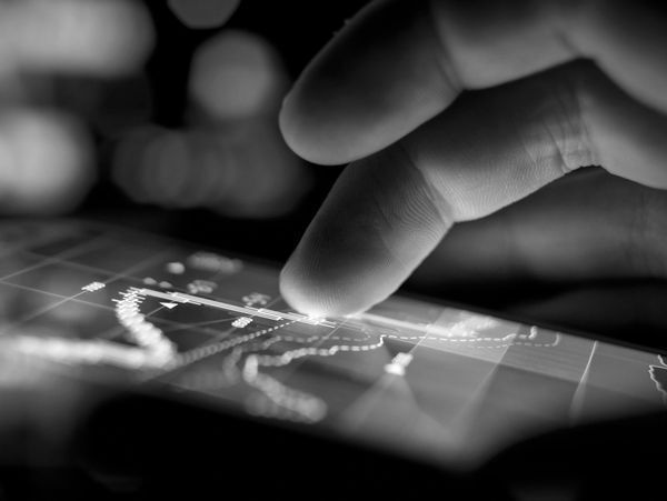 A person 's finger is pointing at a map on a screen.