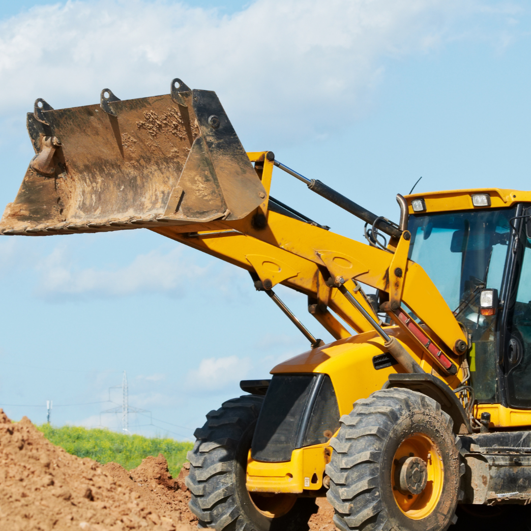 A dump truck is being loaded with rocks by an excavator