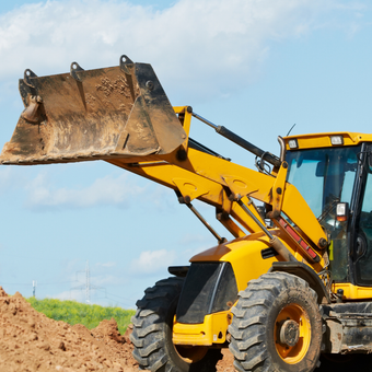 A dump truck is being loaded with rocks by an excavator