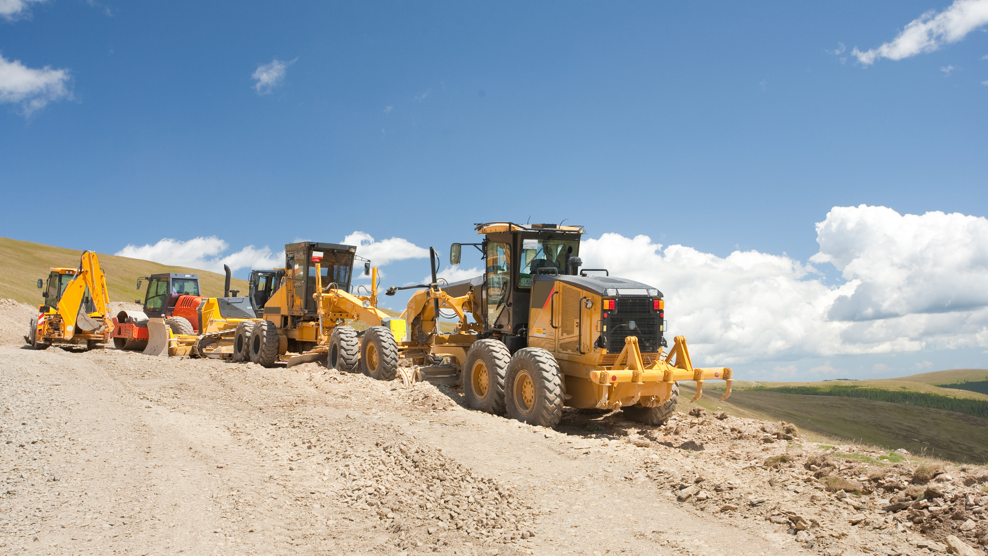Yellow excavator digging dirt on a construction site under a blue sky