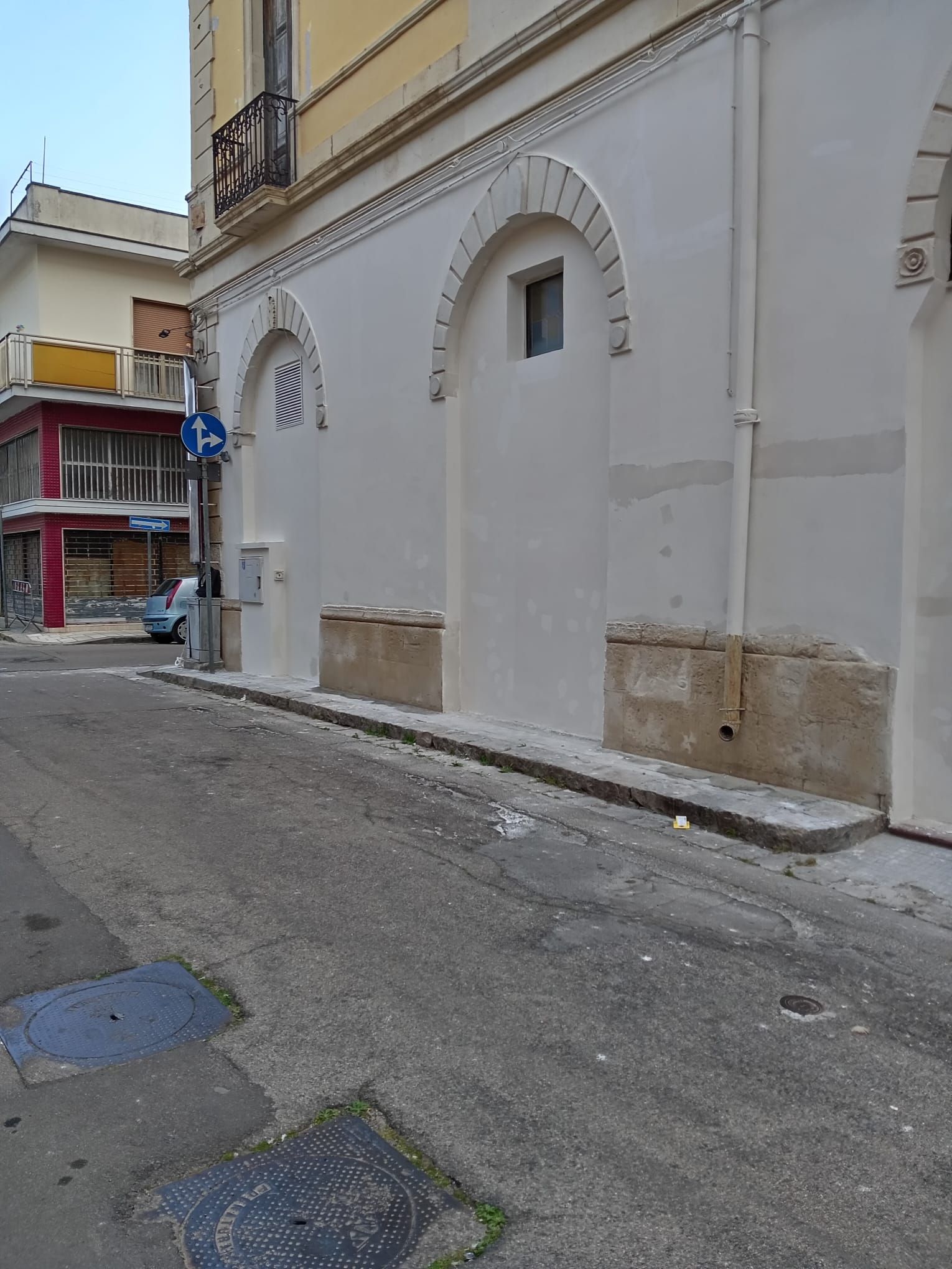 Una strada stretta con un edificio bianco sullo sfondo