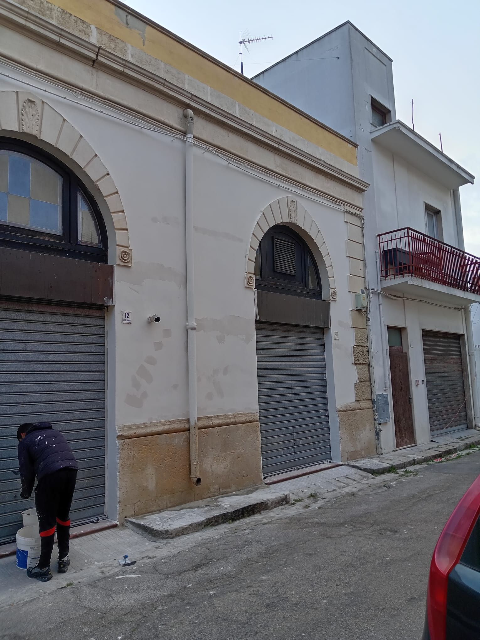 Un uomo è in piedi davanti a un edificio con un garage.