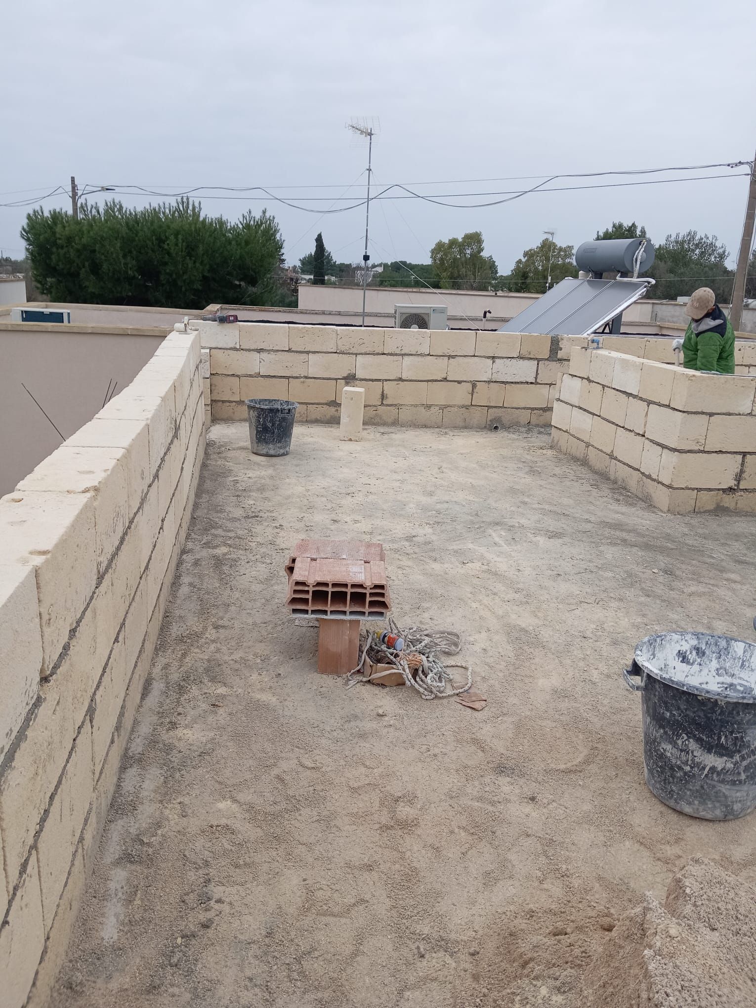 Un muro di mattoni viene costruito sul tetto di un edificio.