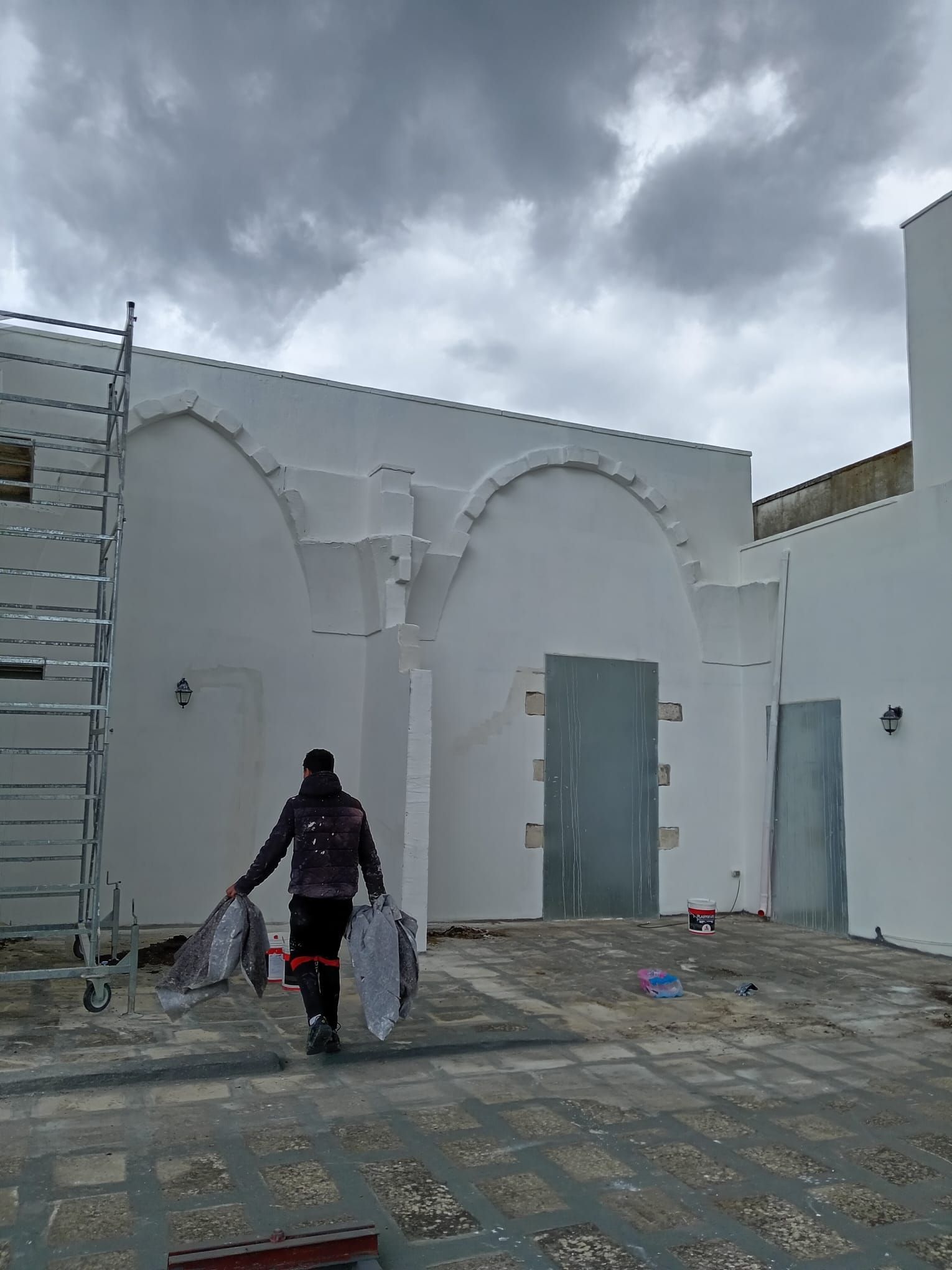 Un uomo cammina davanti a un edificio bianco.
