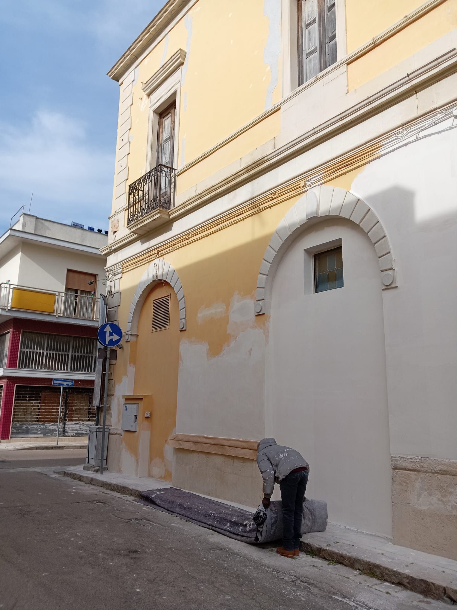Un uomo sta dipingendo il lato di un edificio