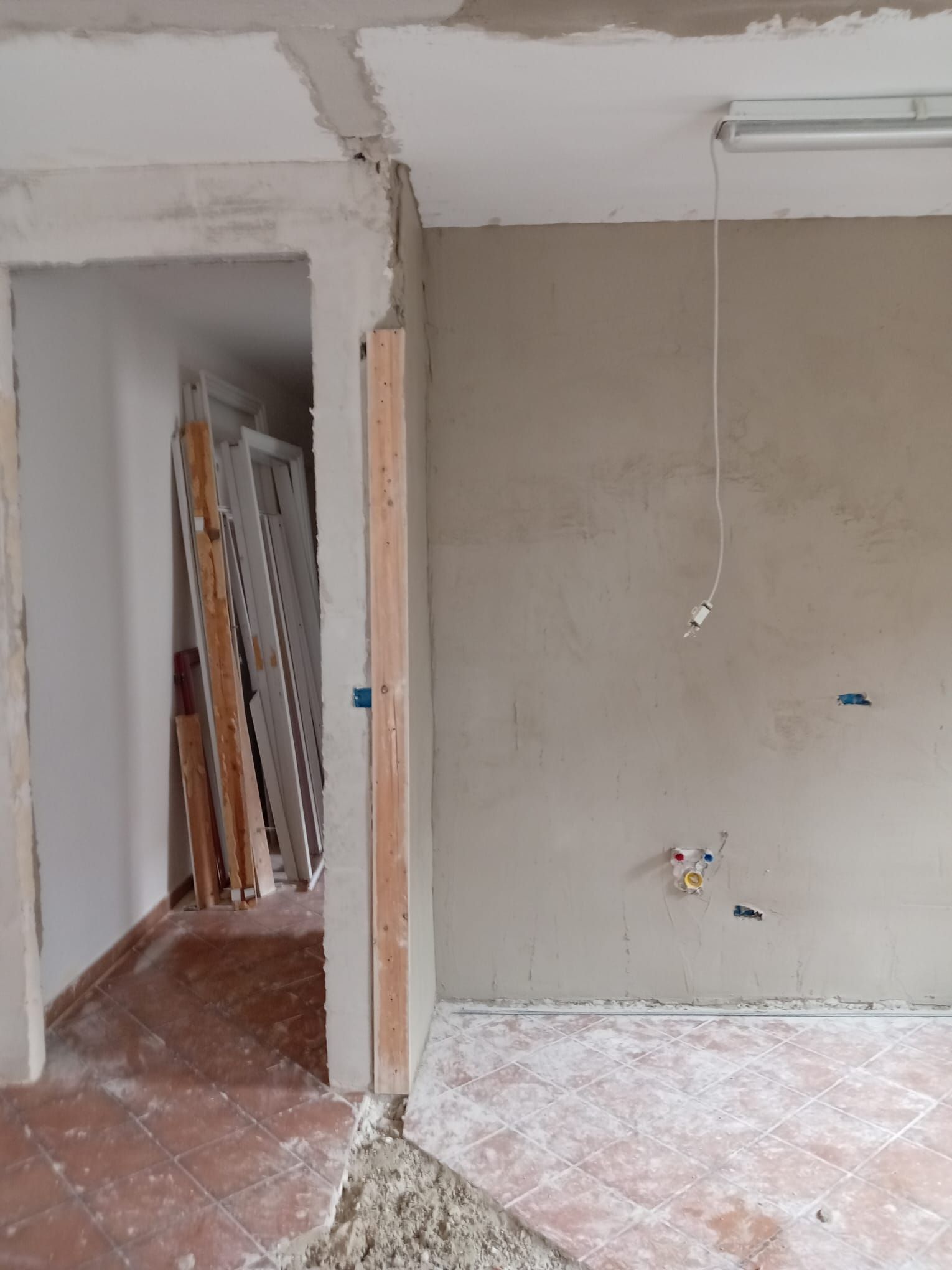 Una stanza vuota con una porta e una luce appesa al soffitto