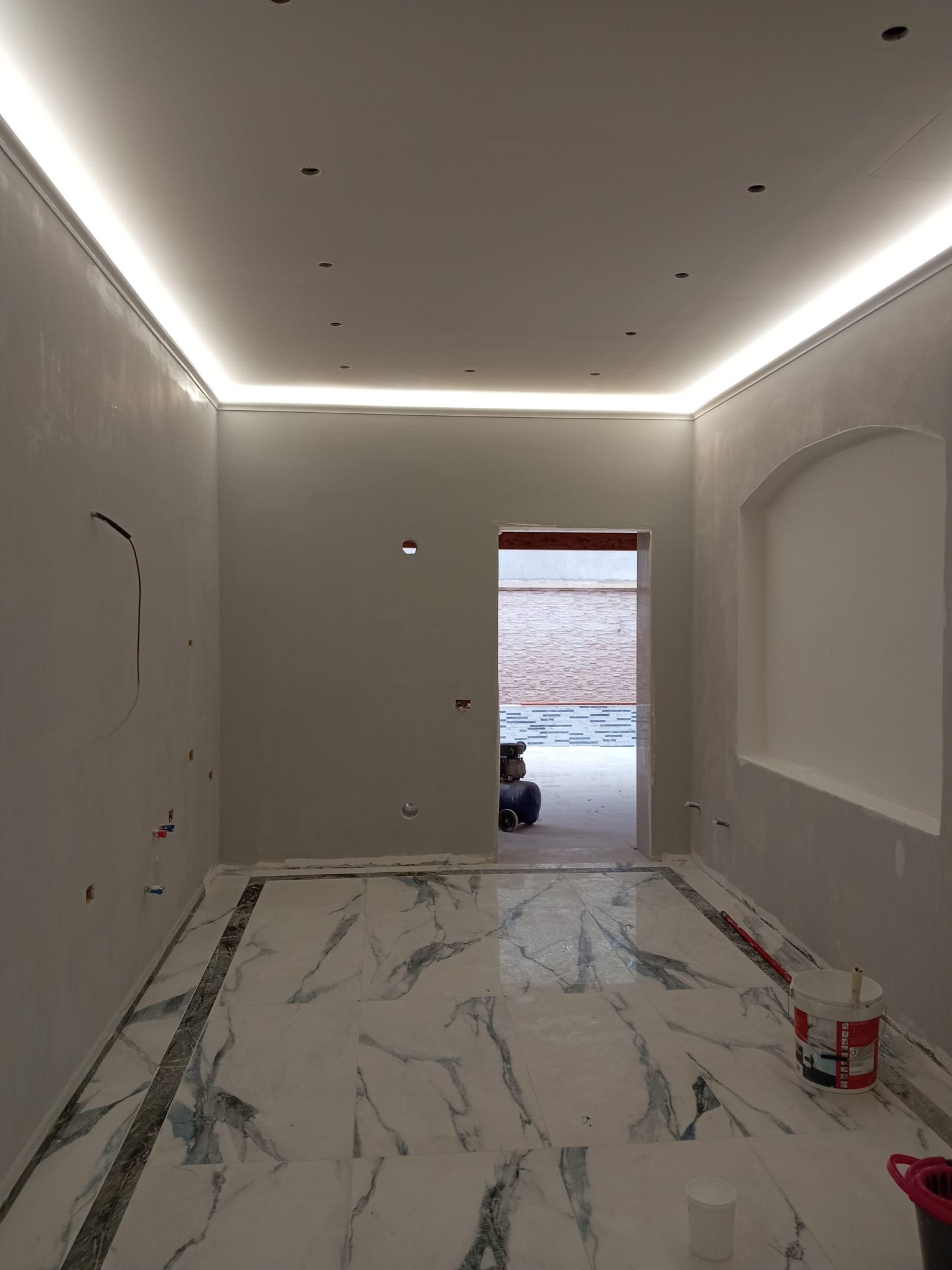 Una stanza con pavimento in marmo e una luce sul soffitto.