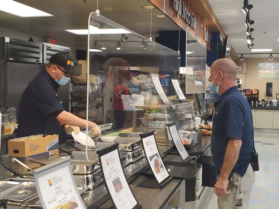 Kevin Cody, left, a recent graduate of New Road School in Warren County, serves food in the Newton Medical Center as part of the Project SEARCH program for students with developmental disabilities.
