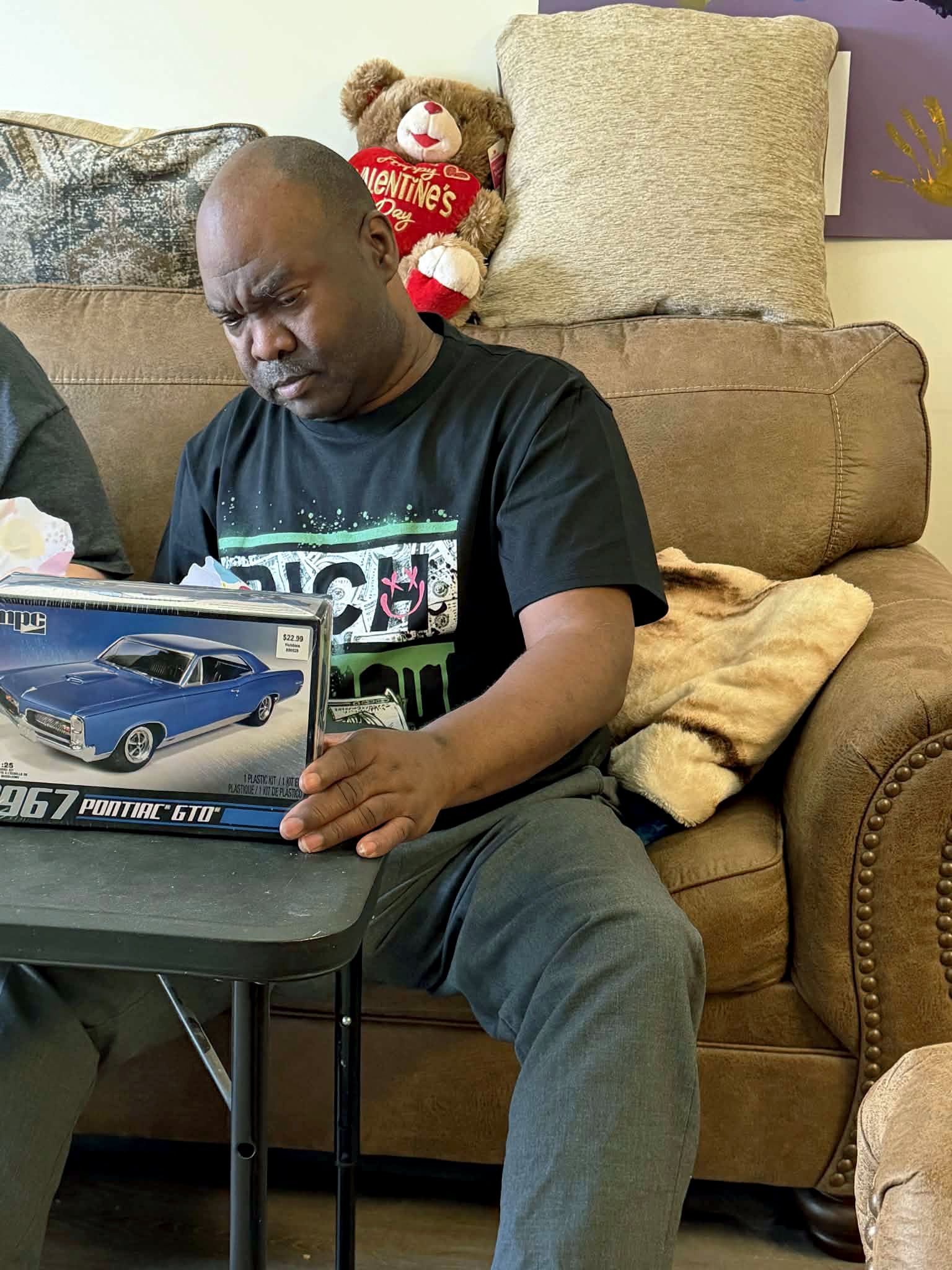 Mike smiling upon opening his new model car.