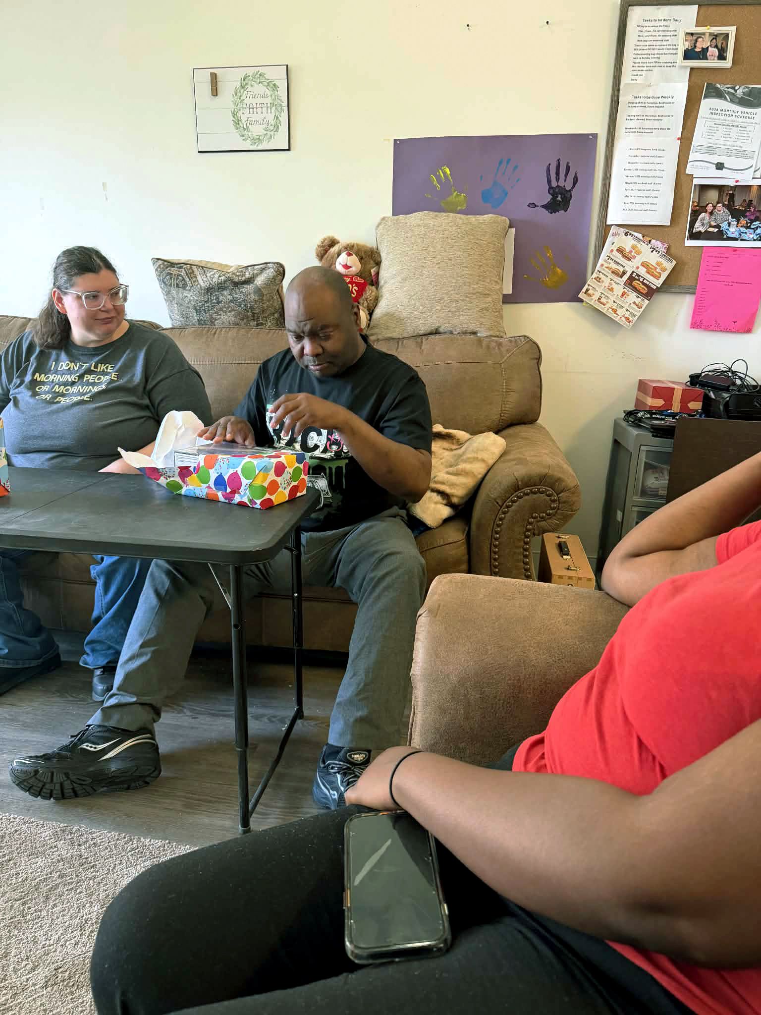 Mike opening another present while Tiffany watches.