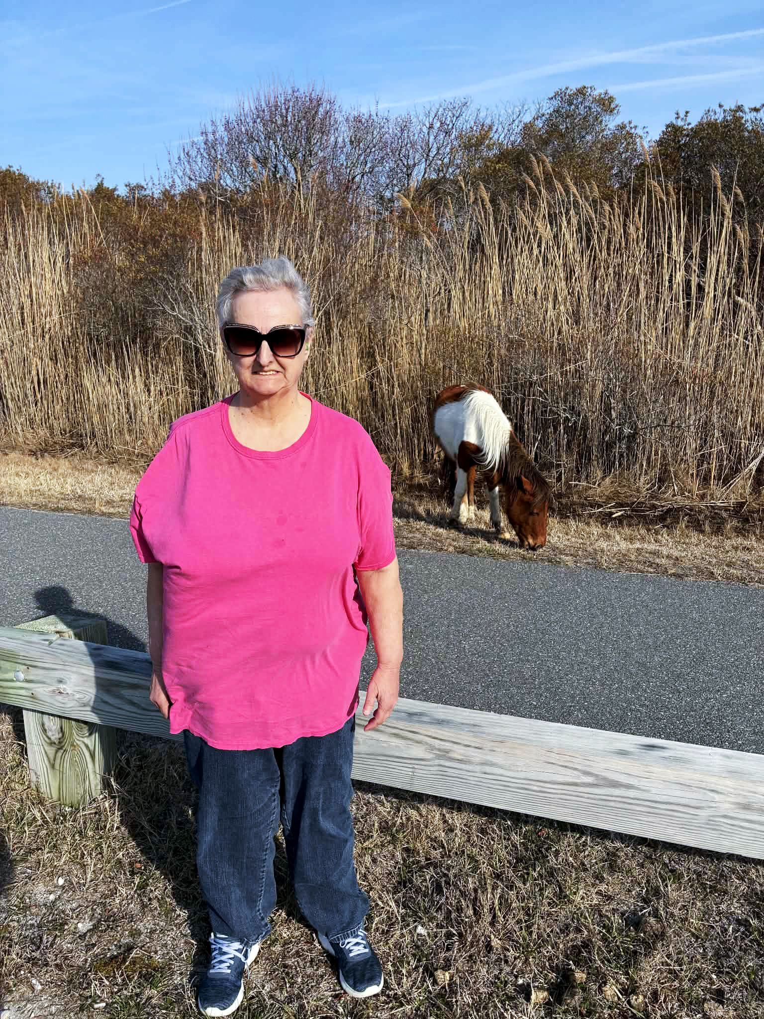 Sandra P poses near an Assateague Pony in March 2026