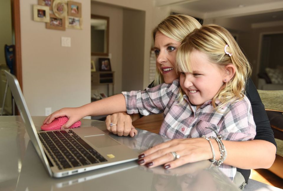 Dapkus and her eight-year-old daughter Isabelle doing virtual learning with her fidget mouse in Plymouth, Michigan. — The Detroit News/TNS