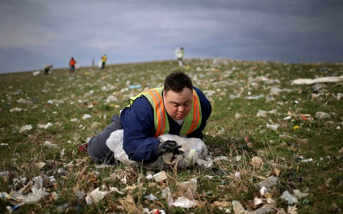 A man with Down syndrome picks up trash for his sheltered workshop job. (David Joles/Star Tribune/TNS)