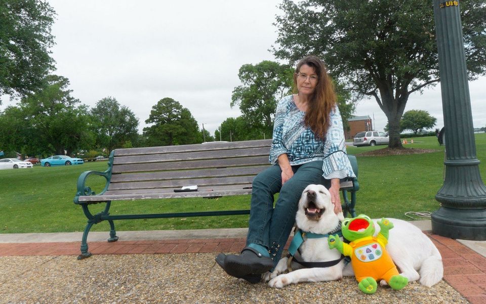 Susan Osborn, photographed in May 2020, sits on a bench in Union Point Park in New Bern, N.C., with her son Noah's service dog, Saxby, and her son's favorite toy. At the time, Noah, a 17-year-old with autism and other developmental disabilities, lived in an intermediate care facility. Because of the coronavirus pandemic, Susan hadn't seen him in more than two months. (Trent Brown/The News & Observer/TNS)