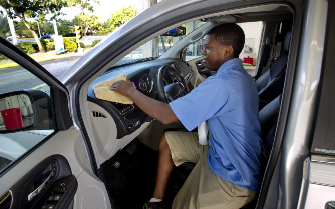 Leonardo Coakley details a car dashboard in 2013 at Rising Tide Car Wash in Parkland, Fla. (Joe Rimkus Jr./Miami Herald/TNS)