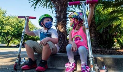 Mason Gottis, left, 9, and his sister Violette, 7, spend their evening riding their scooters.