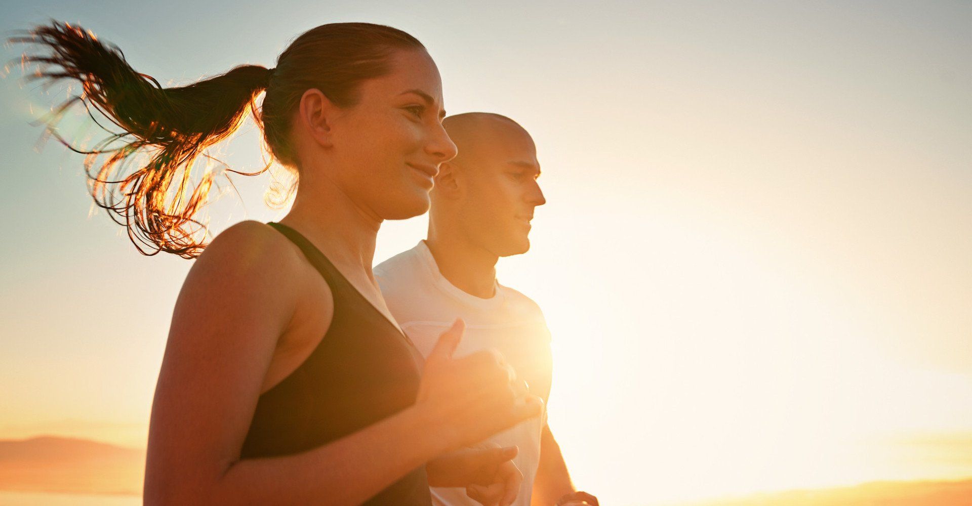 sporty young couple running during sunrise