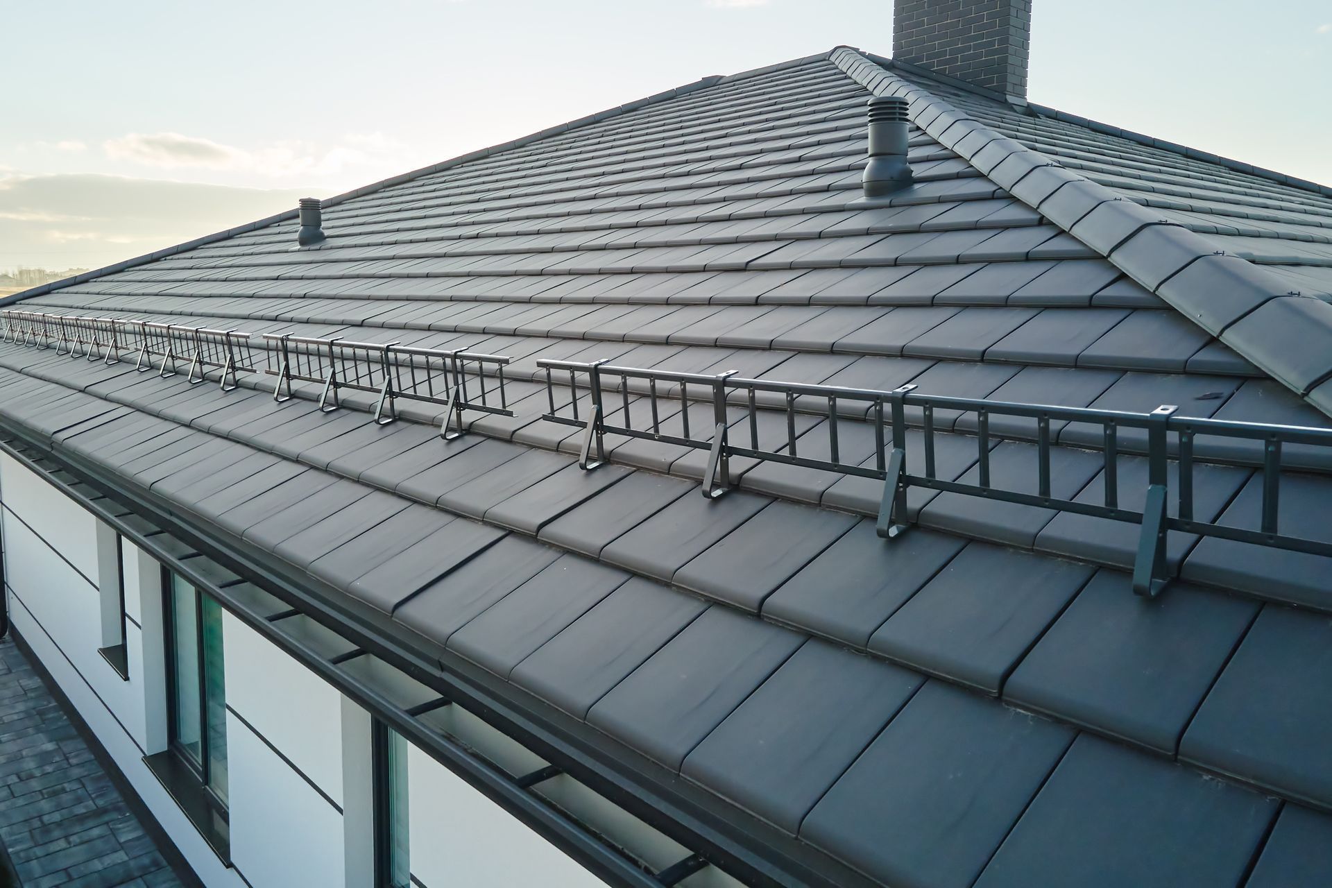 A roof of a house with a ladder attached to it
