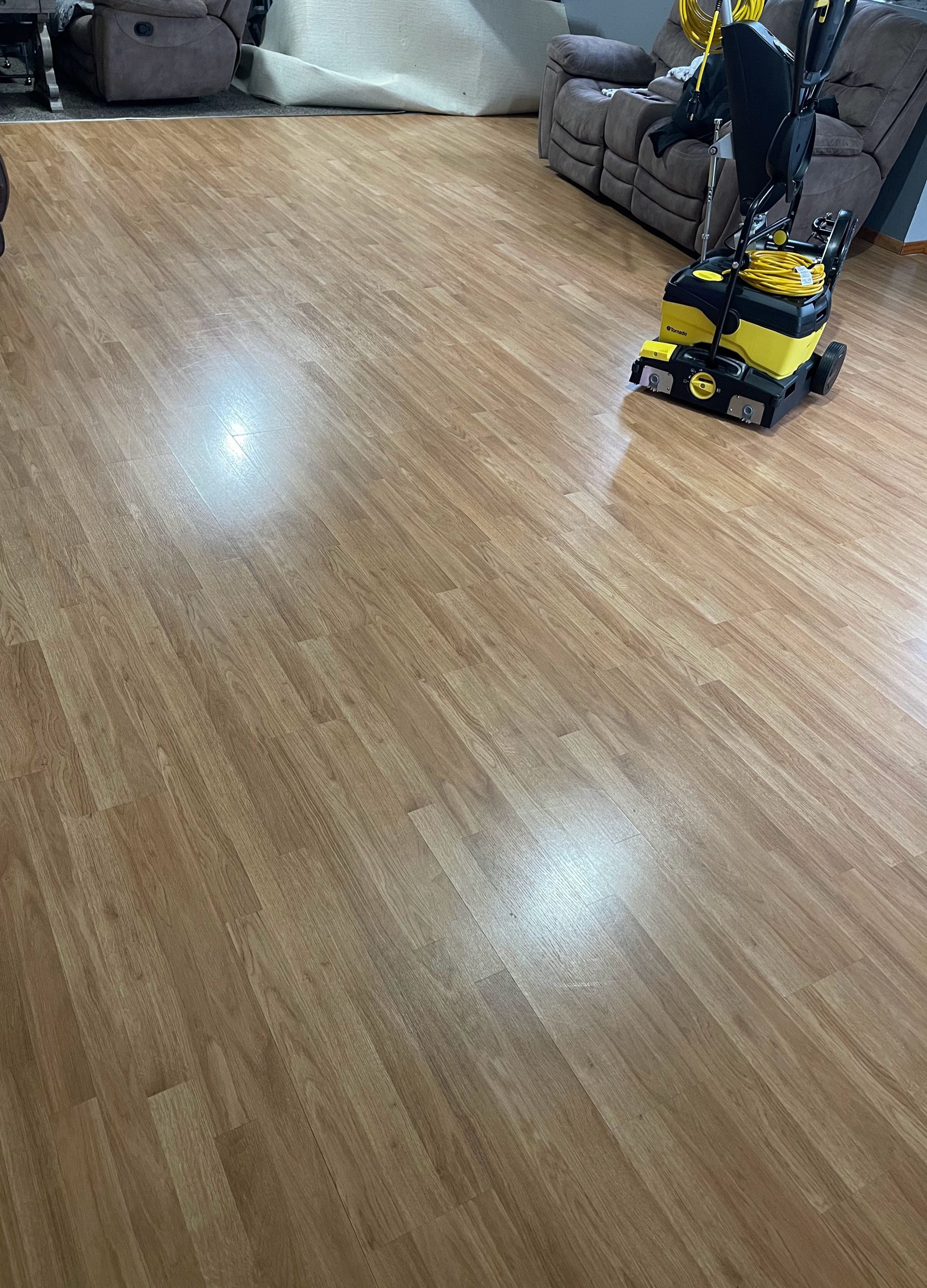 A vacuum cleaner is sitting on a wooden floor in a living room.