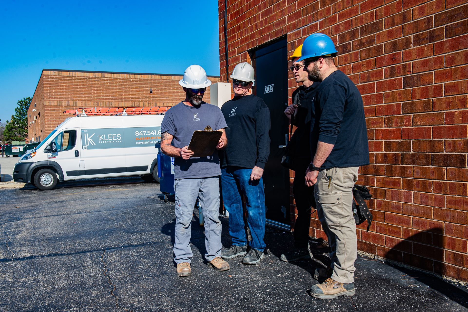 A white utility truck is parked in a parking lot in front of a building.