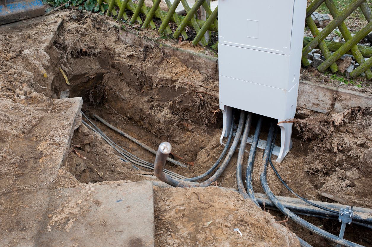 A bunch of wires are coming out of a hole in the ground.