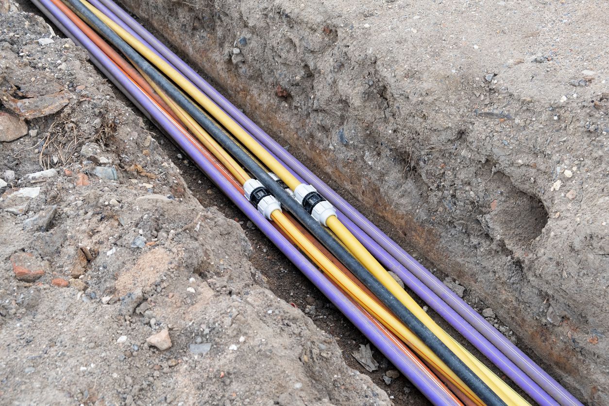 A bunch of colorful wires are laying in the dirt