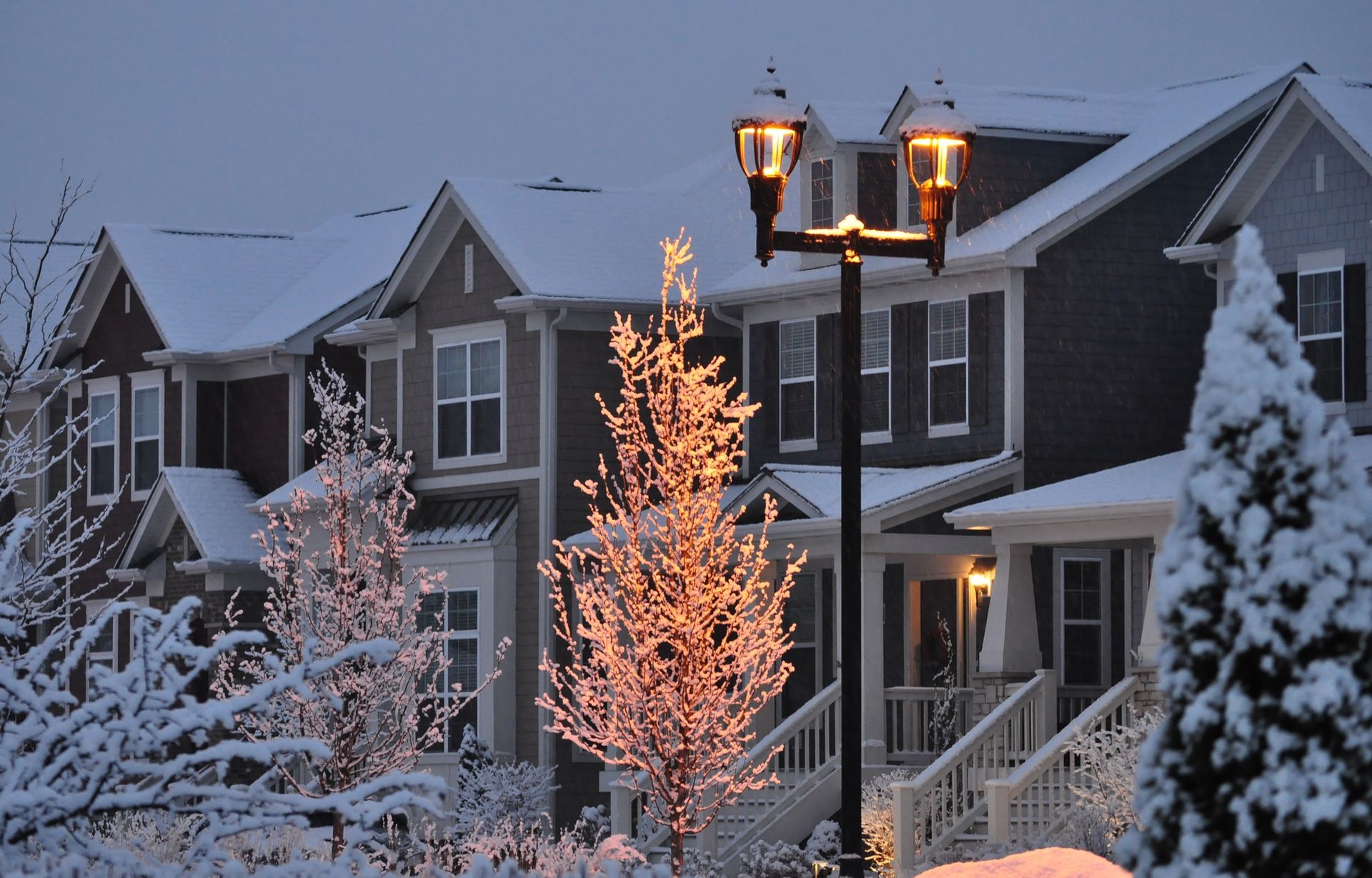 Snow-covered townhouses at dusk.