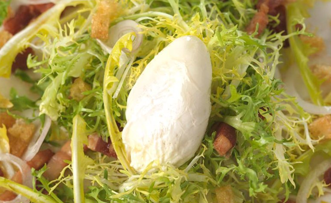 Salad with frisee lettuce, endive, bacon, and croutons.