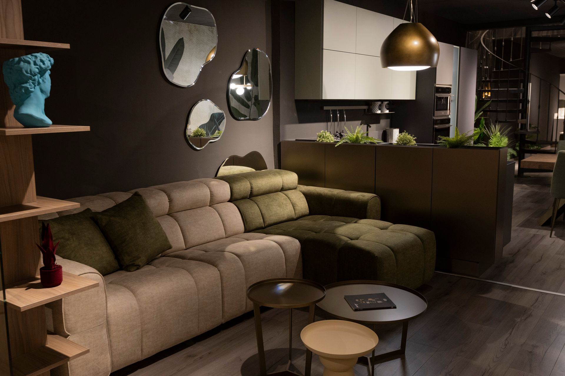 Soggiorno con divano componibile, specchi decorativi e tavolini da caffè.