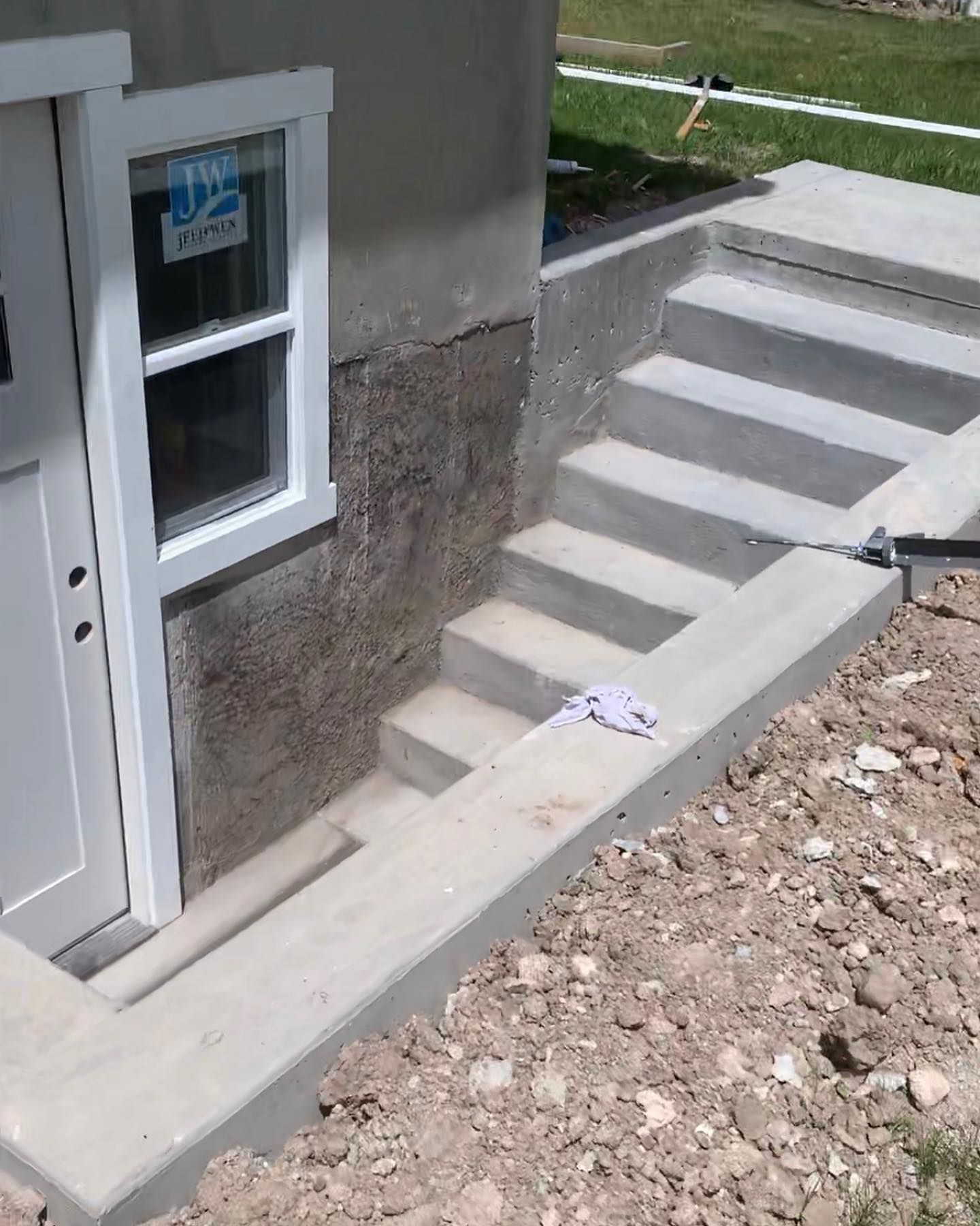 A white door with a window and stairs leading up to it