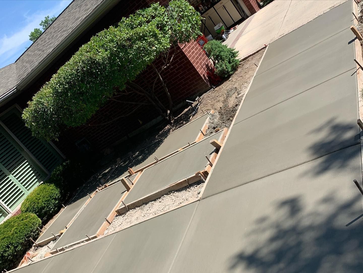 A concrete driveway is being built in front of a house