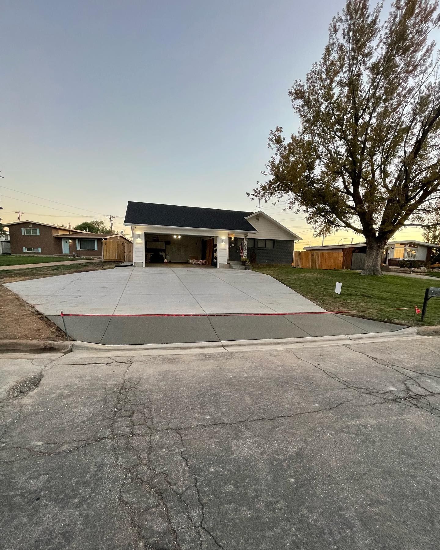 A house with a garage and a concrete driveway in front of it.