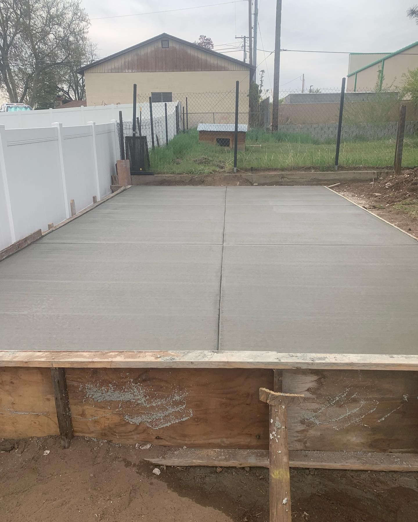 A concrete floor is being built in a backyard.