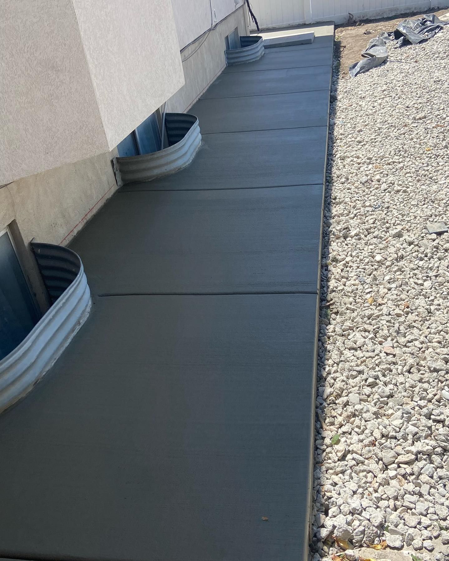 A concrete walkway is being built next to a building.