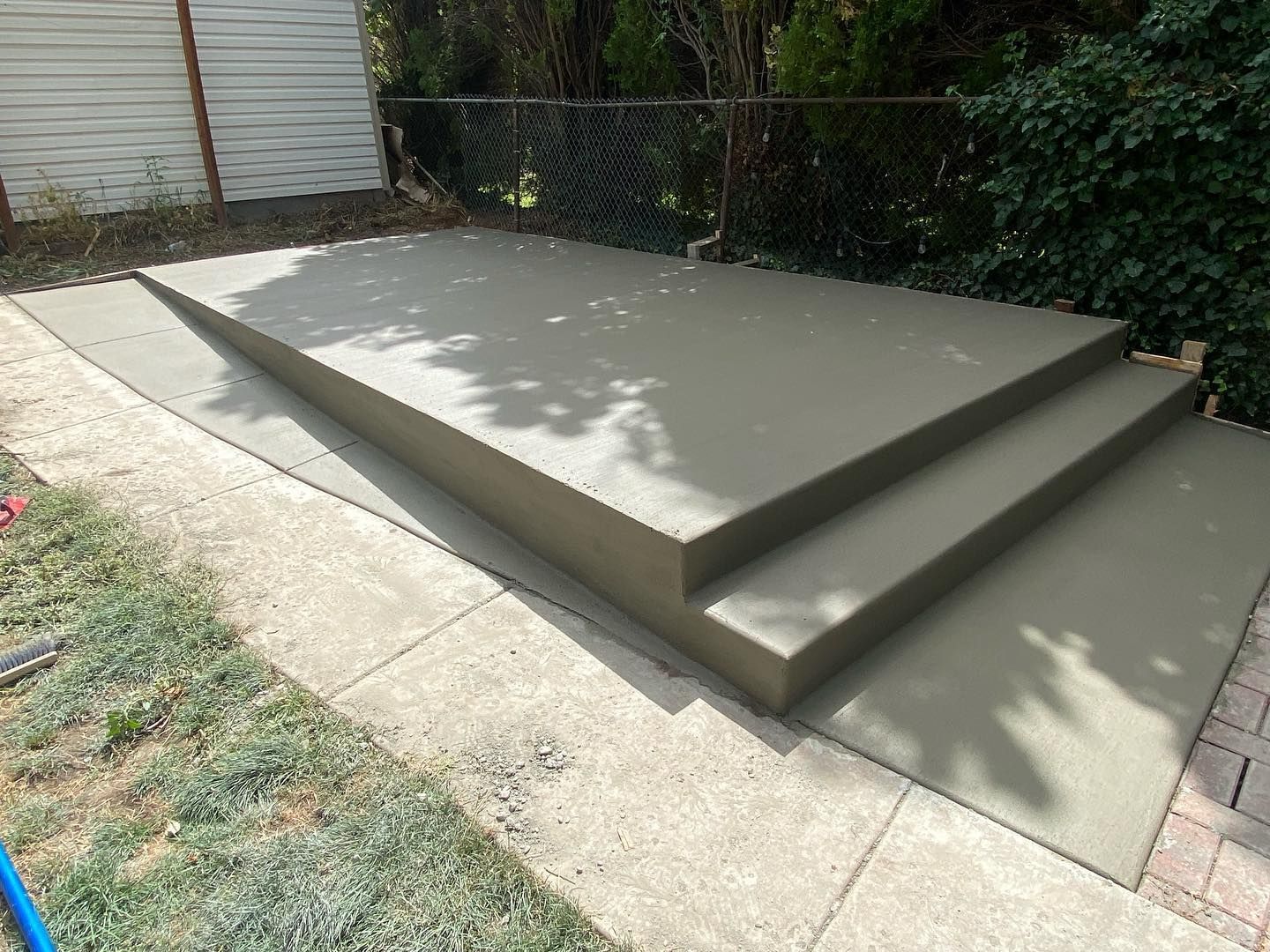 A concrete staircase is being built in a backyard.