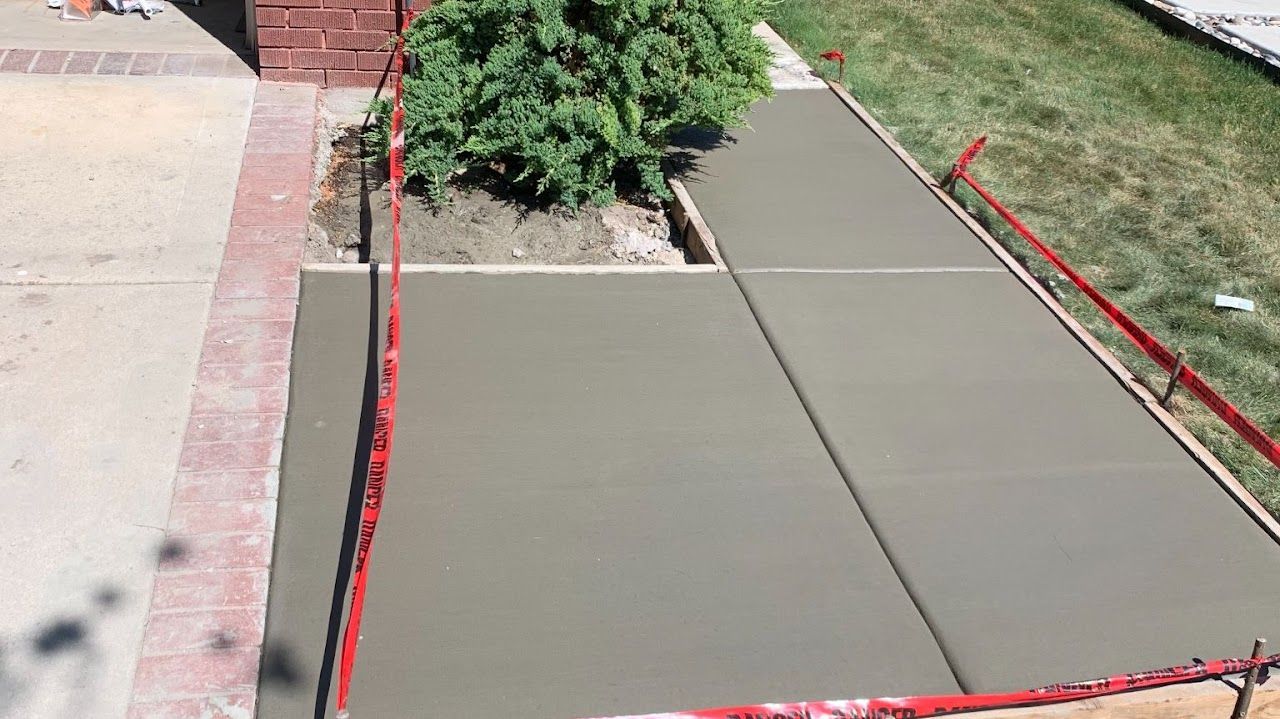 A concrete walkway is being built in front of a brick building.
