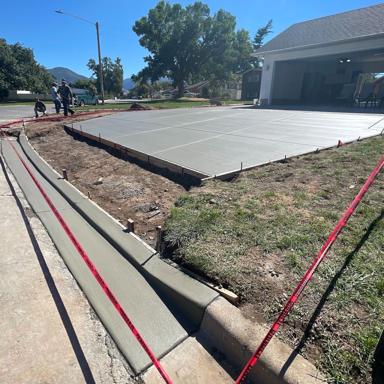 A concrete driveway is being built in front of a house