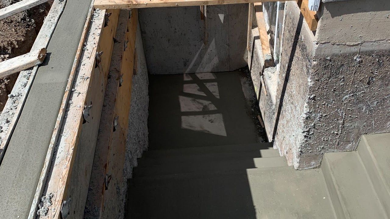 A concrete staircase is being built in a basement.